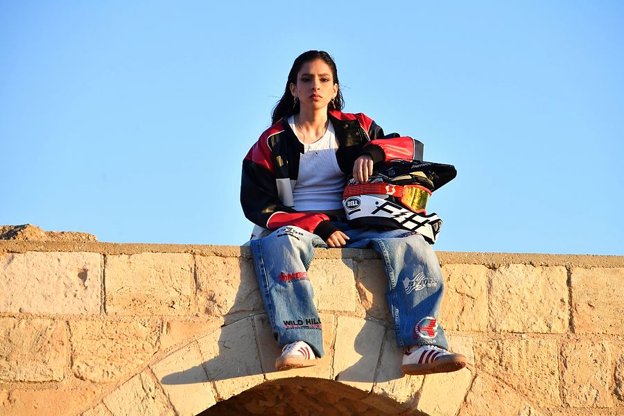 Orr De Loco seated on a stone wall